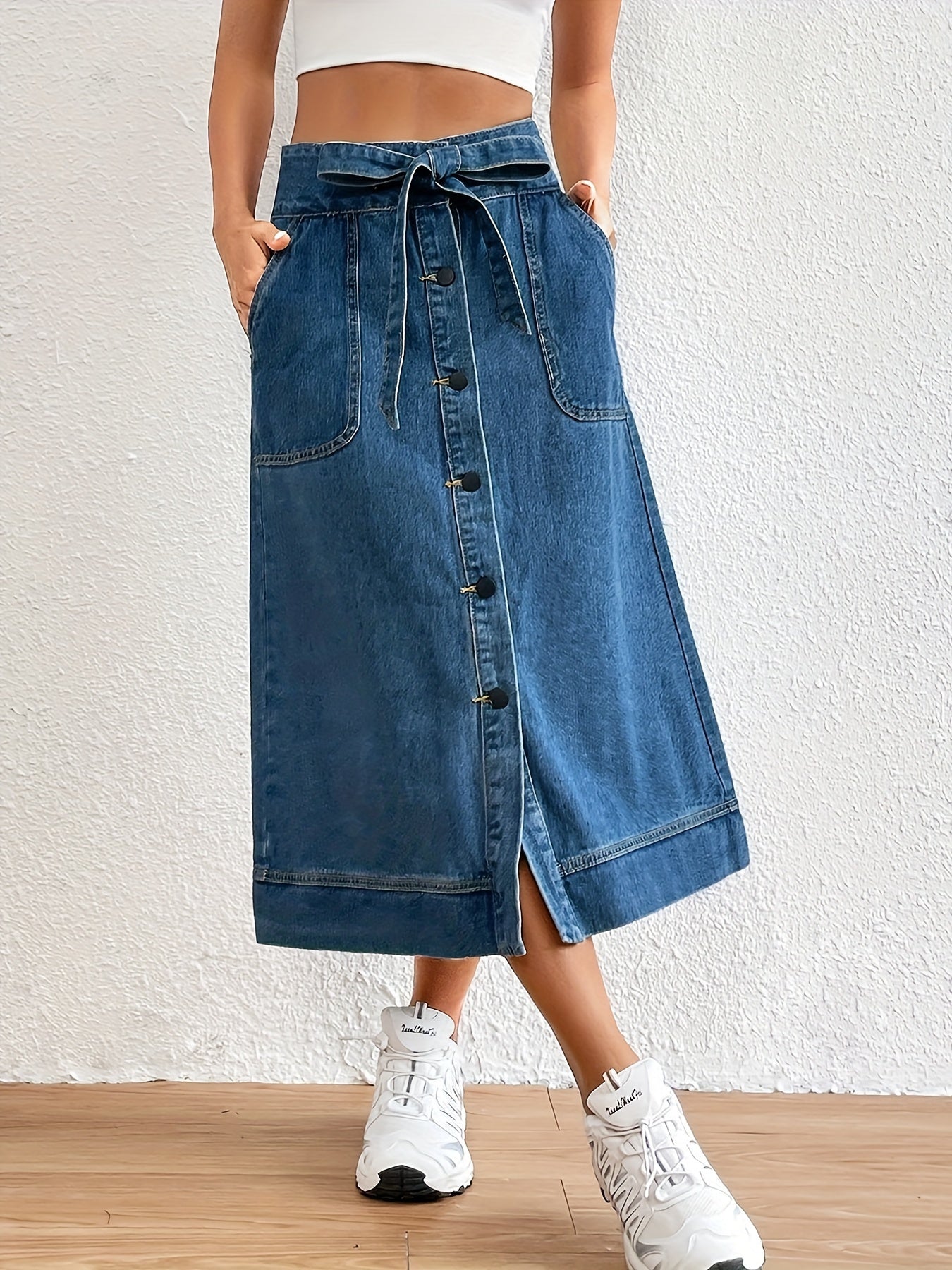 Ontdek de tijdloze elegantie van de denim midi rok met strikceintuur voor een klassieke look. Gemaakt van hoogwaardige denim en perfect voor elke gelegenheid! afbeelding 1